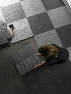 a woman laying on the floor next to two pieces of paper and a paintbrush