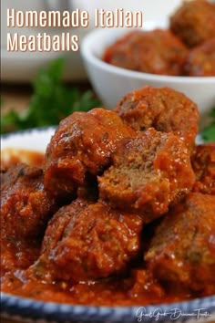 meatballs are piled on top of each other with sauce in the middle and garnished with parsley