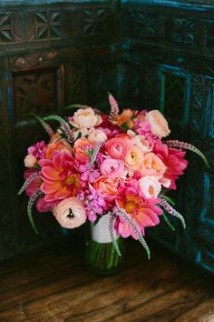 a vase filled with pink and orange flowers