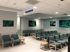 an empty waiting room with blue chairs and pictures on the wall