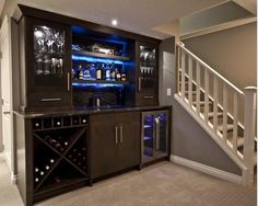 a home bar with wine glasses and bottles on it in the corner of a room