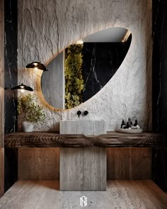 a bathroom with marble counter tops and a round mirror on the wall, along with two lights