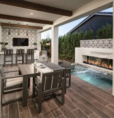 a dining room table with chairs and a fire place in the back ground near a swimming pool