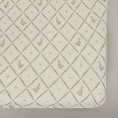 a white and beige blanket with animals on it