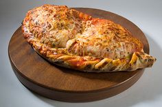 a pizza sitting on top of a wooden cutting board