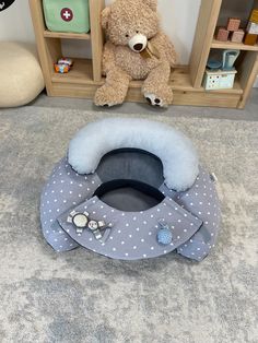 a teddy bear sitting next to a baby bed