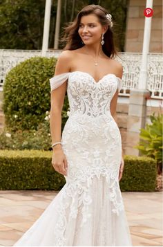 a woman in a wedding dress posing for the camera with her hand on her hip