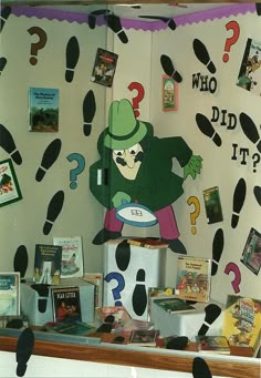 a display case with various books and pictures on the wall, including an image of a cartoon character holding a frisbee