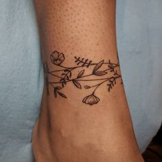 a woman's foot with a flower tattoo on the side of her leg,