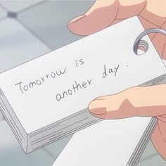 someone holding a piece of paper that says tomorrow is another day