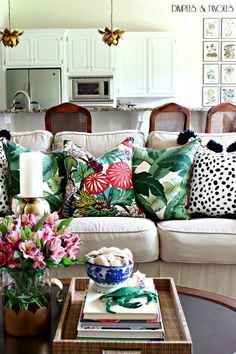 a living room filled with lots of furniture and flowers on top of a coffee table