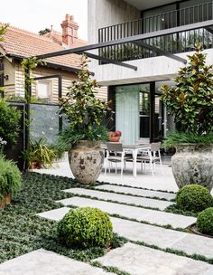 an outdoor patio with potted plants and chairs