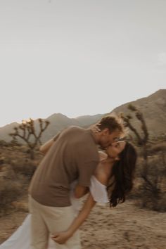 a man and woman kissing in the desert