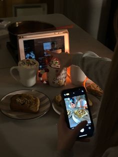 a person taking a photo of food on a table with an appliance in the background