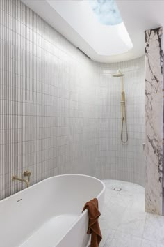 This neutral toned ensuite features a brushed brass shower set, white kit kat tiles, a curved wall and a skylight which is filtering sunlight from above. Timber Sliding Doors, Abi Interiors, Renovation House, Curved Wall, Mcm House, Charming Cottage, Cottage Renovation, Kitchen Sink Taps