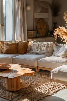 a living room filled with lots of furniture and pillows on top of a rug next to a window