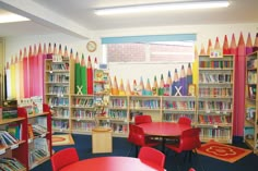 the children's room is filled with colorful books and desks, along with chairs