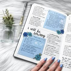 a woman's hand with blue nail polish on top of an open bible book