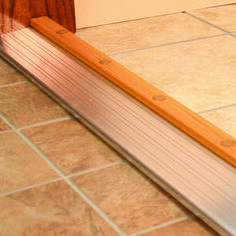 a close up of a wooden door handle on a tile floor with a wood frame