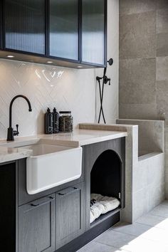 a kitchen with black cabinets and white counter tops