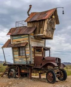 an old truck with a house on it's back in the middle of nowhere