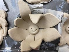 clay flowers with faces on them sitting on top of a table next to other clay pieces