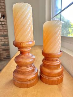 two candles sitting on top of a wooden table