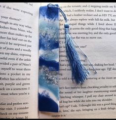 an open book with a tassel on top of it next to a bookmark