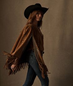 The Sueded Fringe Cape exudes western elegance with its unique blend of style elements. Crafted from sueded fringe that adds dynamic movement, this cape features eye-catching metallic accents for that cowgirl sparkle. Its open front design offers versatility and ease, making it a standout piece for layering. Model is 5'10.5. One size. Barn Boots, Fringe Cape, Ut Austin, Cowgirl Costume, Fur Accessories, Dynamic Movement, Women Lifestyle, Small Handbags, Lifestyle Shop