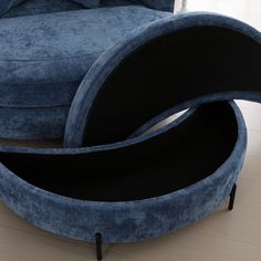 a blue couch sitting on top of a hard wood floor next to a chair and ottoman