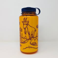 a glass jar with an image of a goat painted on the front and side, sitting on a white surface