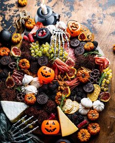 a wooden table topped with lots of different types of halloween foods and decorations on top of it