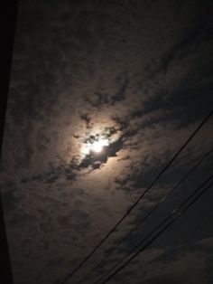 the moon is shining brightly in the cloudy sky