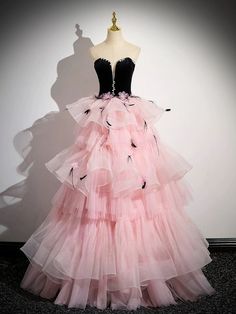 Make a glamorous statement at your next soirée with our Black and Pink Tulle Party Dress, a spectacular ensemble that perfectly marries boldness with elegance. This striking gown features a luxurious black velvet bodice that gracefully transitions into a vibrant pink tulle skirt, setting a dramatic and fashionable tone. Adorned with charming pink floral accents, the skirt brings a playful and romantic flair to the design. A dazzling crystal-embellished waistline draws the eye, accentuating your curves with sophistication. Ideal for upscale parties or as a distinctive choice for an evening gown, this dress ensures that all eyes will be on you. Step into the night with confidence and style in this exquisite pink evening gown, tailored to celebrate plus-size beauty. Black Evening Dress For Debutante Ball, Black Tulle Ball Gown For Party, Black Organza Evening Dress For Prom, Black Organza Gown For Gala, Glamorous Black Evening Dress For Debutante Ball, Glamorous Velvet Wedding Dress, Glamorous Black Organza Evening Dress, Black Organza Glamorous Evening Dress, Velvet Dresses For Wedding Gala