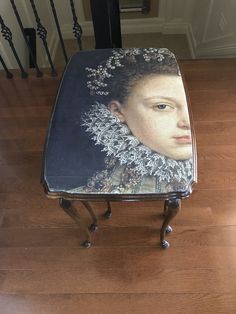 a small stool with a painting on it