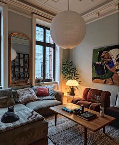 a living room filled with furniture and a large painting hanging on the wall above it