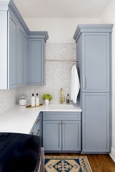 a kitchen with blue cabinets and white counter tops