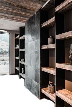 an empty room with wooden shelves and glass doors