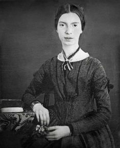 an old black and white photo of a woman with a necklace on her neck, wearing a dress