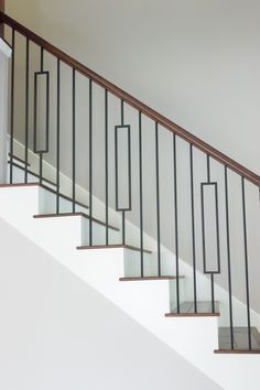 a white stair case with metal handrails and glass balconies