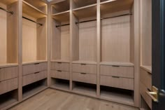 an empty walk - in closet with wooden shelves and drawers