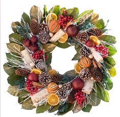 a christmas wreath with oranges, pine cones and other decorations