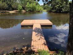 a wooden dock sitting in the middle of a lake