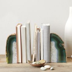 some books are sitting on a table next to a vase and other items in front of them