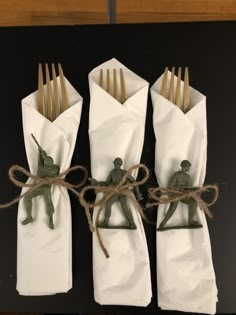 four napkins tied with twine and small army figurines on them