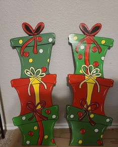 two green and red christmas gift boxes with bows on them sitting next to each other