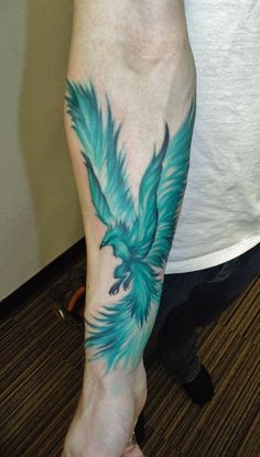 a person with a tattoo on their arm and foot that has a blue bird on it