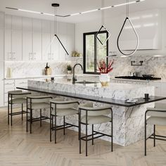 a large kitchen with marble counter tops and white cabinets, along with bar stools