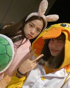 two girls dressed up as pokemon and pikachu, one pointing at the camera