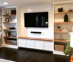 a flat screen tv mounted to the side of a white wall in a living room